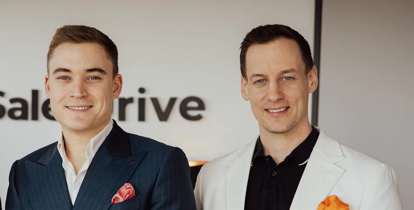 Lukas Lehner und Alexander Kiraly vor der SalesDrive-Logowand im Büro in Wien
